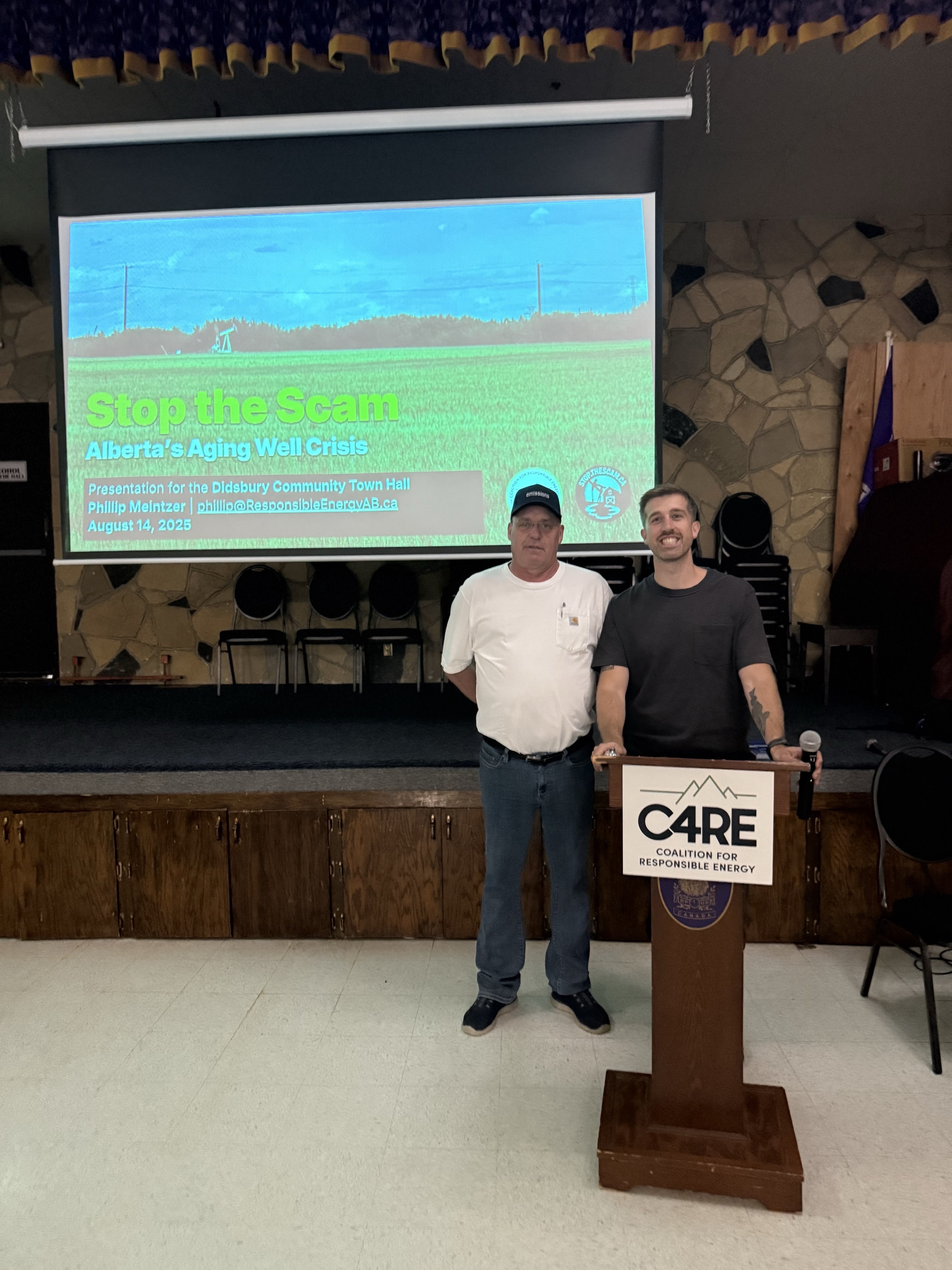 Speaker presenting at the Didsbury town hall, with attendees listening to presentations about the Mature Asset Strategy and its impact on rural communities